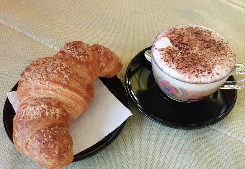 Breakfast with cornetto and cappuccino