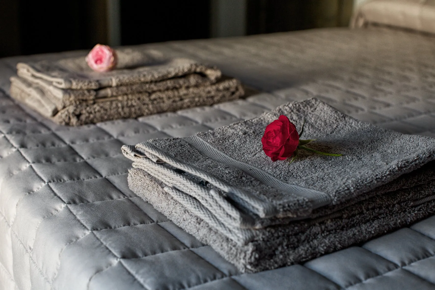 Folded towels on bed sheets